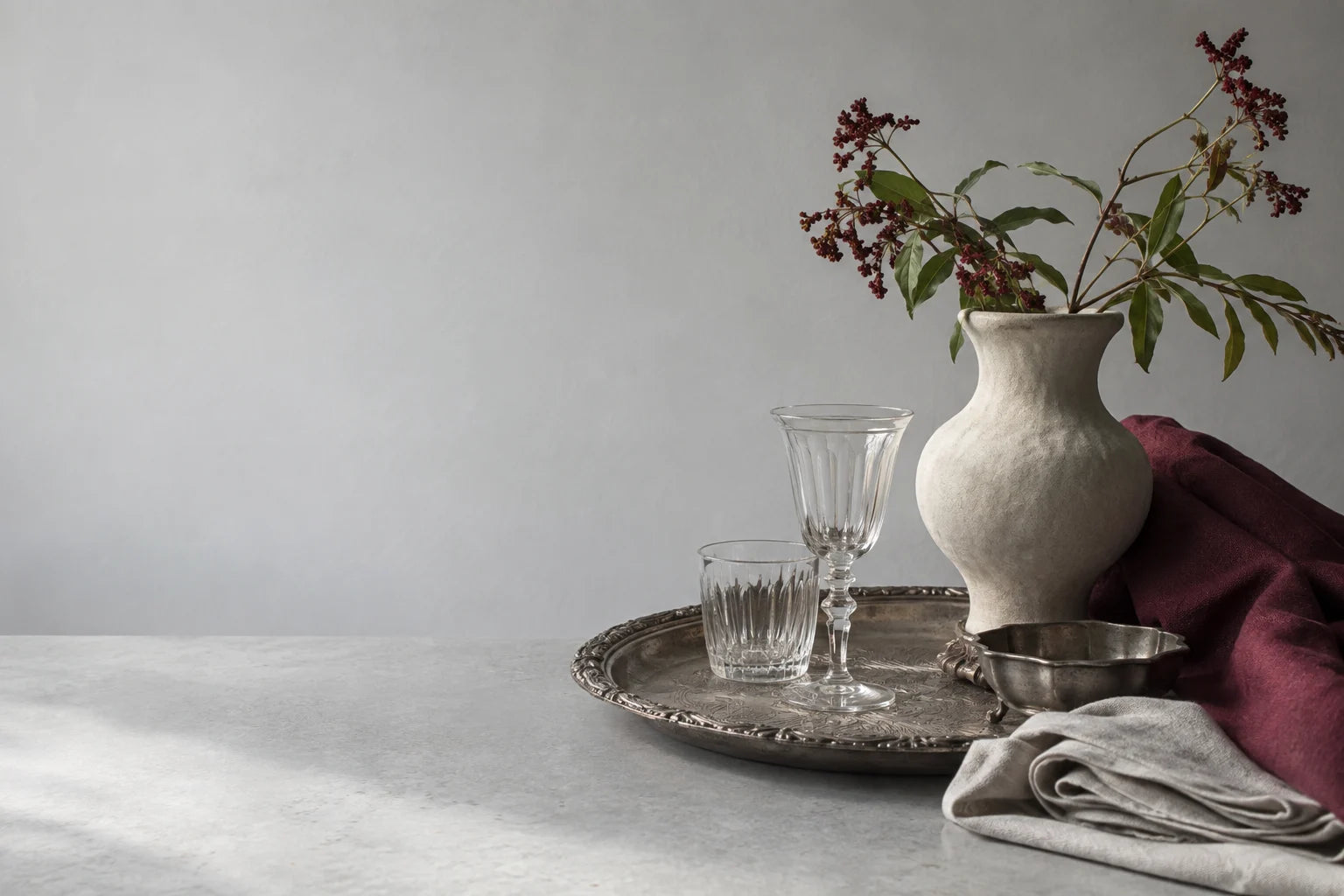 Vintage silver, ceramics and glass arranged with soft linen